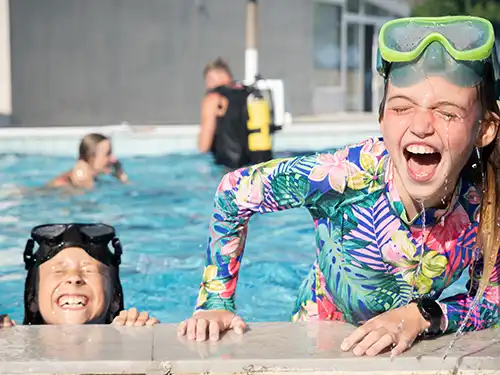 Zwei Mädchen plantschen im Swimmingpool